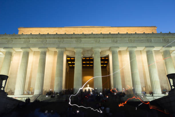 Long exposure scene at the Abraham Lincoln Memorial in Washington DC, with flash lights from visiting tourists. Above the illuminated columns is a frieze with reliefs of some states. Long exposure scene at the Abraham Lincoln Memorial in Washington DC, with flash lights from visiting tourists. Above the illuminated columns is a frieze with reliefs of some states. washington dc slavery the mall lincoln memorial stock pictures, royalty-free photos & images