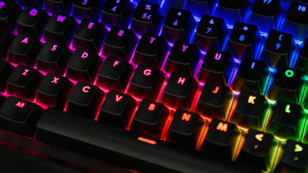 istock Backlit keyboard closeup with rainbow colors - Pink, blue, orange, green 1127735192