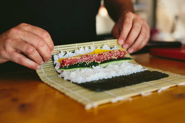 Crop man making sushi stock photo