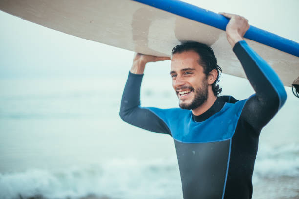 surfer przewożący deskę surfingową - surfing surf wave men zdjęcia i obrazy z banku zdjęć