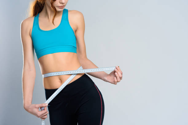 istock Close Up. Girl Measures Waist With Centimeter. 1127737946