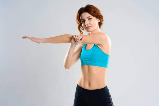 istock Red Haired Girl Does Arms Stretching Exercises. 1127737948