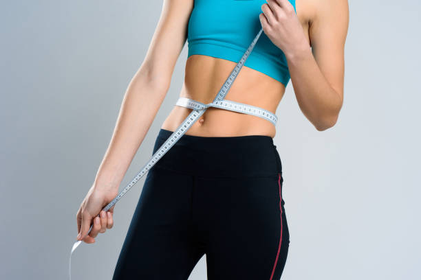 istock Close Up. Girl Measures Waist With Centimeter. 1127737965