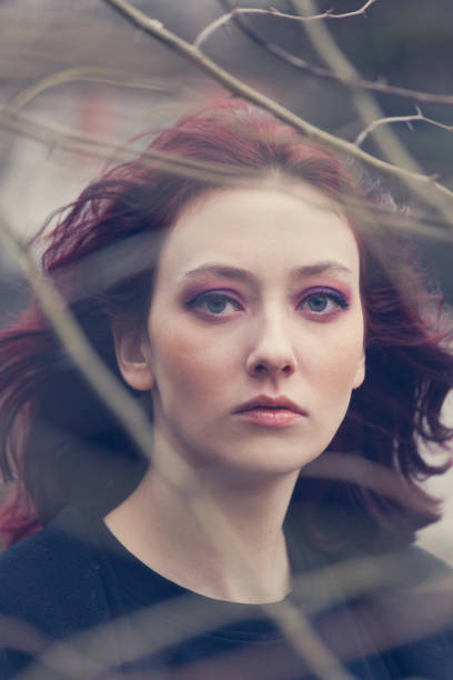 istock young blue eyes woman portrait through the tree 1127739387