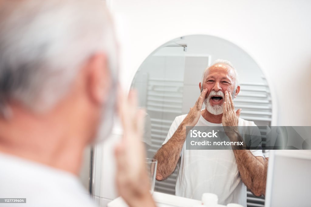 Senior glücklich in den Spiegel. - Lizenzfrei Creme Stock-Foto