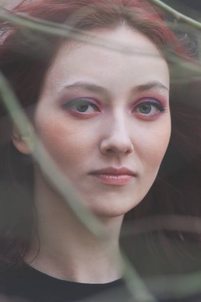 istock young blue eyes woman portrait through the tree 1127739610