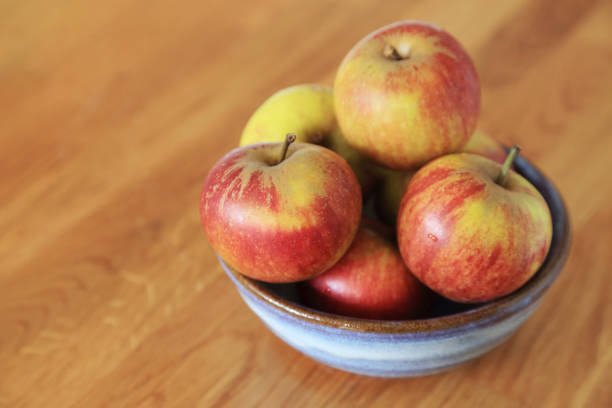 istock Composition with Yellow Red Apples in ceramic bowl on wooden background. 1127739614
