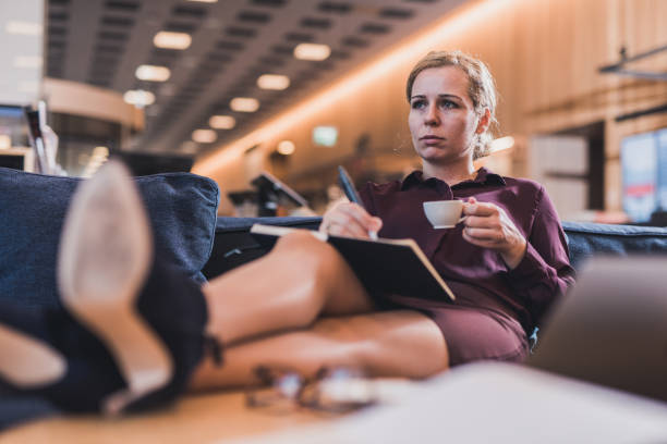 istock Businesswoman drinking coffee and writing. 1127739715