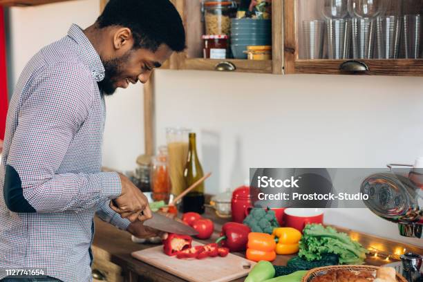 Africanamerican Man Cutting Bell Pepper In Kitchen Stock Photo - Download Image Now