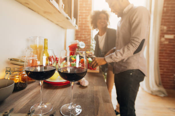 Romantic black couple preparing healthy meal together Romantic couple drinking wine and preparing healthy meal together, copy space maroon photos stock pictures, royalty-free photos & images