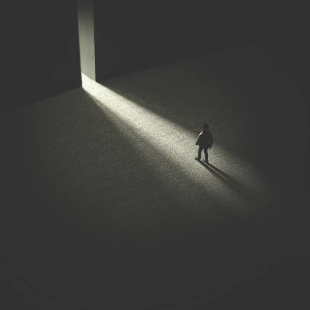 istock man walking in the night following light 1127742615