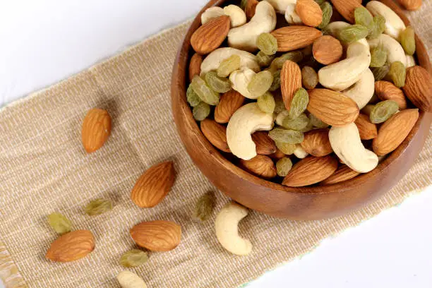 Assorted nuts on white, dry fruits, mix nuts, almond, cashew, raisins
