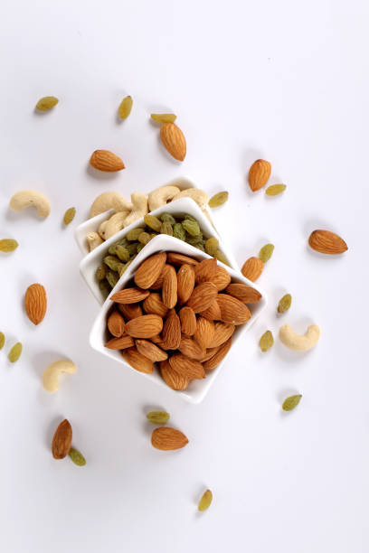istock Assorted nuts on white, dry fruits, mix nuts, almond, cashew, raisins 1127743259