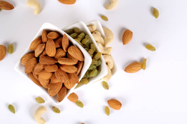 istock Assorted nuts on white, dry fruits, mix nuts, almond, cashew, raisins 1127743302