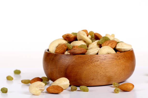 istock Assorted nuts on white, dry fruits, mix nuts, almond, cashew, raisins 1127744436