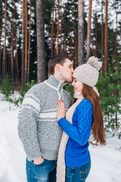 istock happy couple hugging and laughing outdoors in winter forest 1127744628