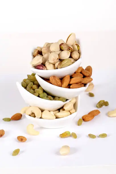 Assorted nuts on white, dry fruits, mix nuts, almond, cashew, pistachio, raisin