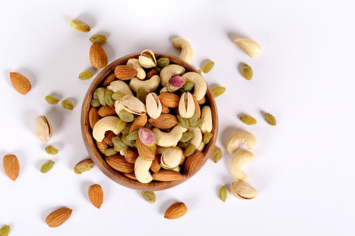 Assorted nuts on white, dry fruits, mix nuts, almond, cashew, pistachio, raisin