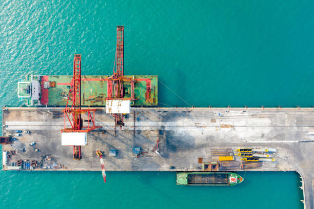 istock Aerial top view. Container ship in pier with crane bridge carries out export and import business in the sea. 1127748068