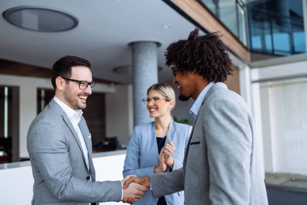 istock Diverse male employees shaking hands in hallway 1127750008