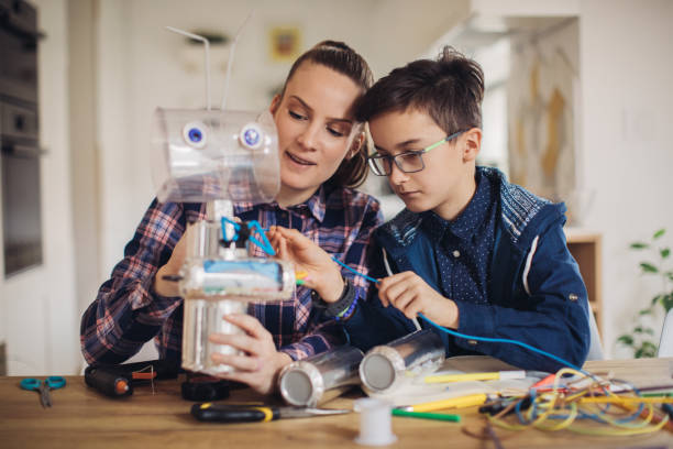 Boy making robot toy for school project with his sister