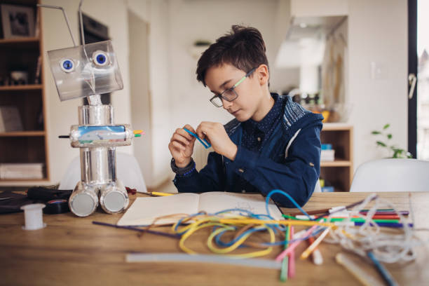 istock Little boy making robot toy of recycling material for school project 1127750497