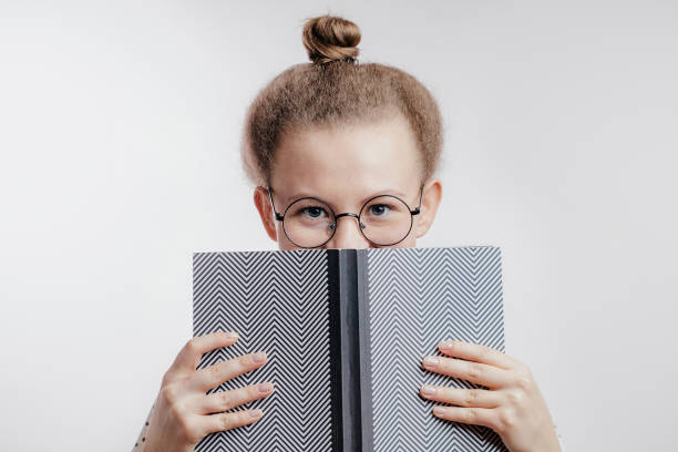 istock young woman closing her face with book 1127751257