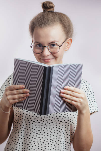 istock good-looking woman with book looking to camera 1127751267
