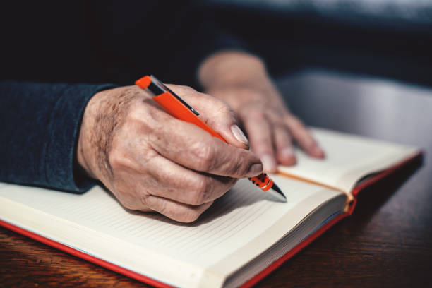 istock Elderly woman writing 1127751297