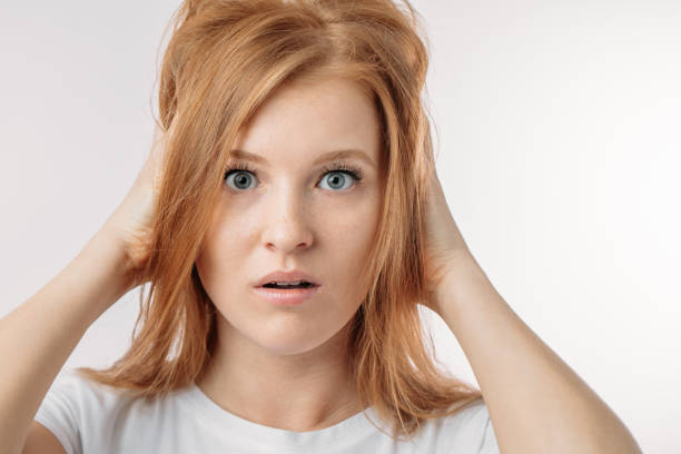 驚いて、ショックを受けた女性が、再び仕事に遅刻です。顔の表情のコンセプト - terrified hairdresser hairstyle color image ストックフォトと画像