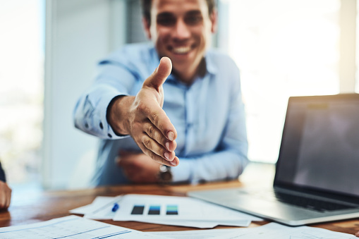 Closeup shot of an unrecognizable businessman extending a handshake in an office