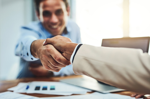 Closeup shot of two businesspeople shaking hands in an office