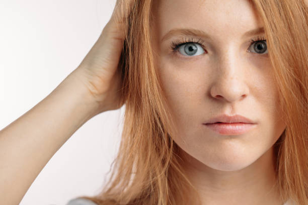 彼女の頭を抱えている深刻な redhair モデル。トリミングされた写真をクローズ アップ - terrified hairdresser hairstyle color image ストックフォトと画像