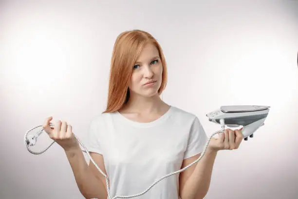 redhair woman hates doing the ironong. household chores. domestic work concept. isolated white background