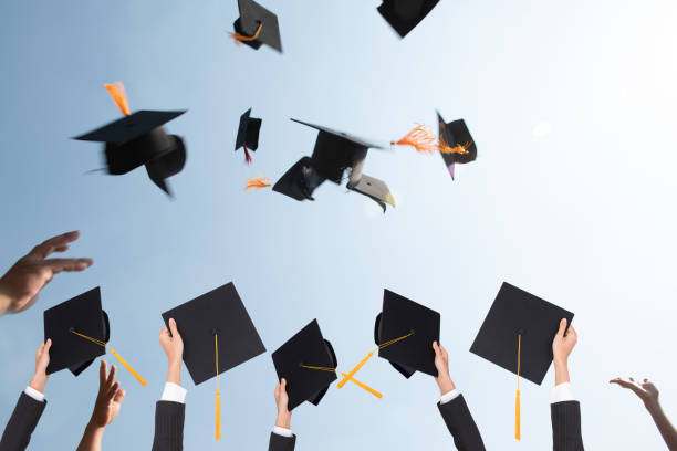 istock Black hat of the graduates floating in the sky. 1127760278