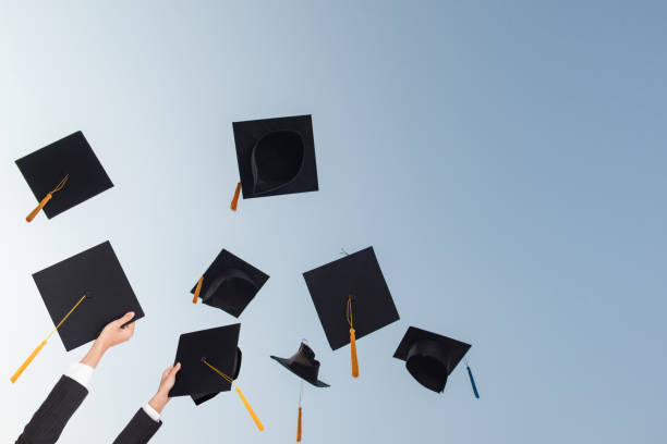istock Black hat of the graduates floating in the sky. 1127760306
