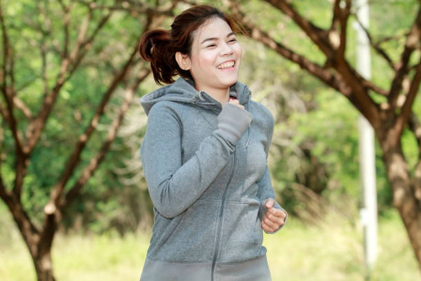 istock Smiling Young Woman Jogging On Road 1127765303