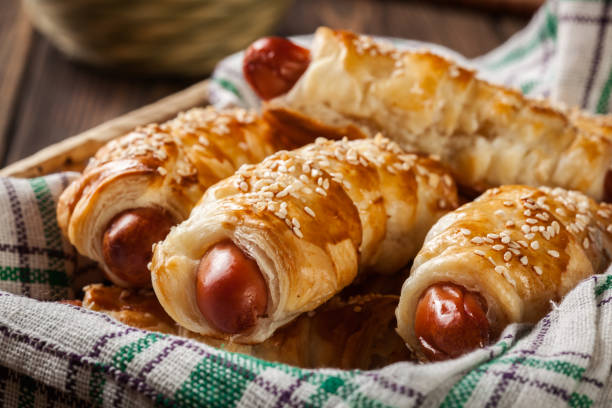 hot-dog würstchen in blätterteig gebacken gerollt - blanket pig hot dog sausage stock-fotos und bilder