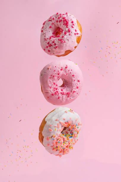 istock Three tasty and sweet donuts with caramel on a pink background 1127768739