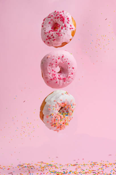 istock Three tasty and sweet donuts with caramel on a pink background 1127768964