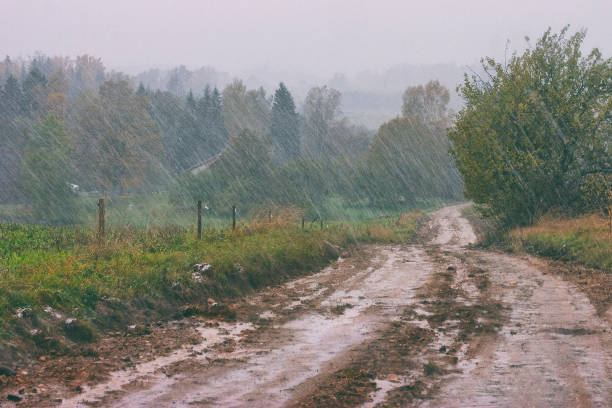 Heavy spring rain in the countryside Heavy spring rain on the hills in the countryside with a brown clay road heavy rainfall stock pictures, royalty-free photos & images