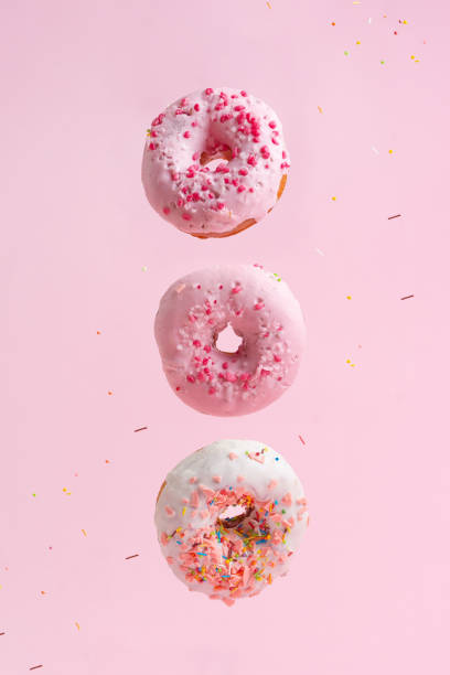 istock Three tasty and sweet donuts with caramel on a pink background 1127769484