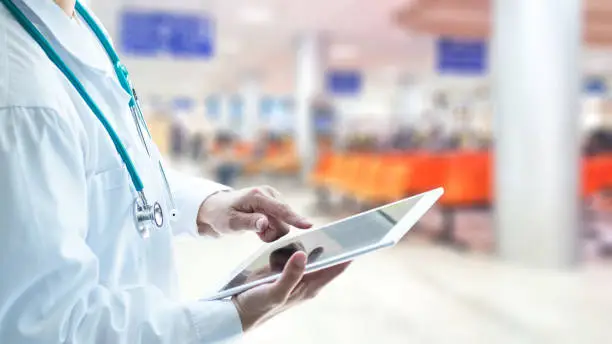 Photo of Healthcare professional medical doctor using tablet and smartphone for consult patient via online: Physician working tele-consultation: Hospital e-healthcare professionalism Digital health concept.