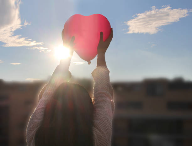 istock Girl holding heart shaped balloon 1127771868