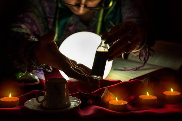 istock Woman fortune teller holding and showing bottle with potion 1127773206