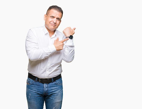 Middle age arab elegant man over isolated background In hurry pointing to watch time, impatience, upset and angry for deadline delay