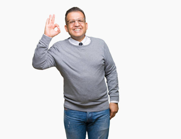 istock Middle age bussines arab man wearing glasses over isolated background smiling positive doing ok sign with hand and fingers. Successful expression. 1127775946