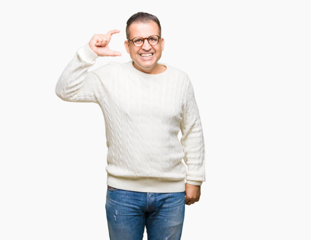 istock Middle age arab man wearing glasses over isolated background smiling and confident gesturing with hand doing size sign with fingers while looking and the camera. Measure concept. 1127776033