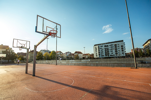 Sunlit basketball court outside village, The Netherlands.