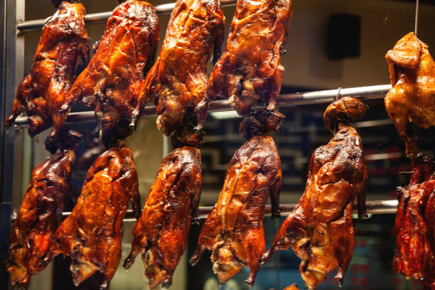 istock Whole cooked chickens hanging in window 1127778046